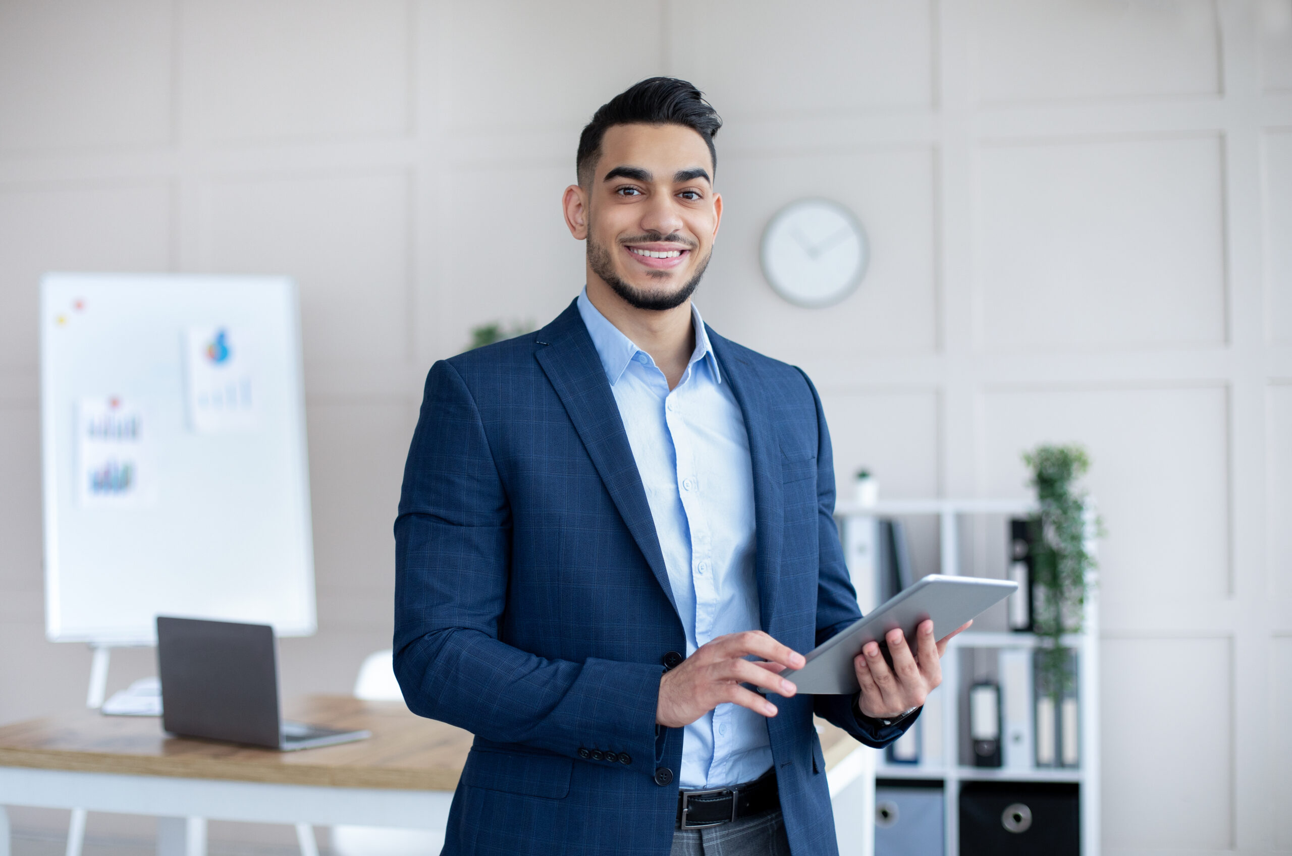 Businessman smiling while holding a tablet